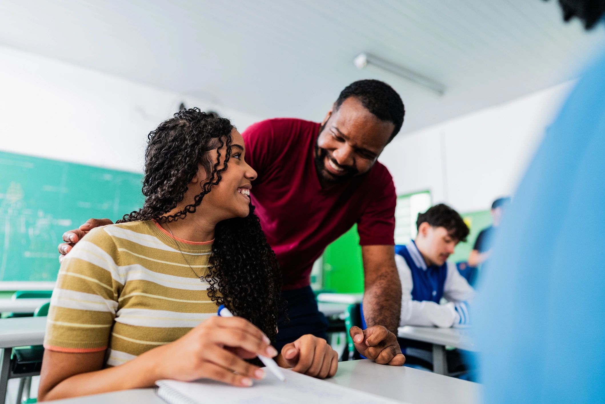 Teacher mentoring a student in a classroom