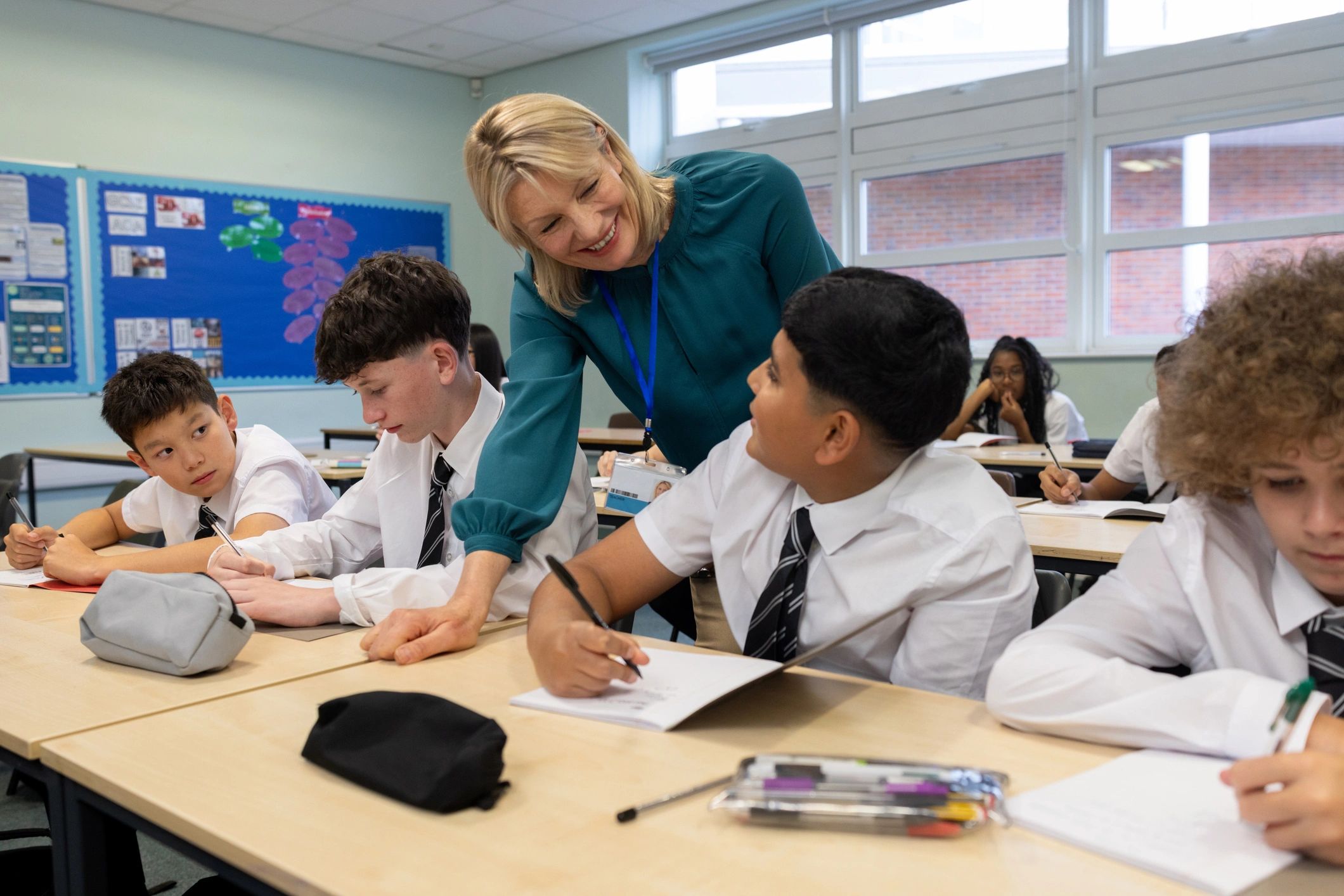 Teacher supporting students in a bright classroom